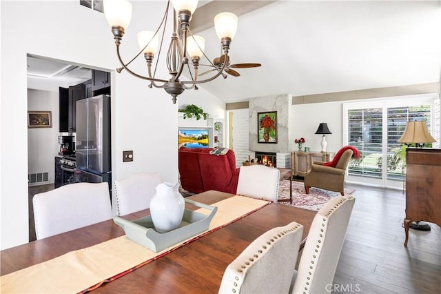 dining area featuring ceiling fan, a large fireplace, lofted ceiling, and dark hardwood / wood-style flooring