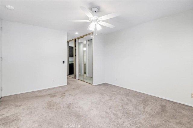 carpeted empty room with ceiling fan and baseboards