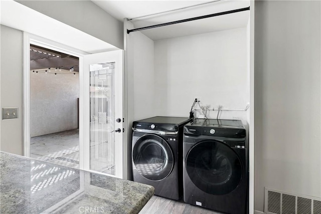 washroom with laundry area, visible vents, and washer and clothes dryer