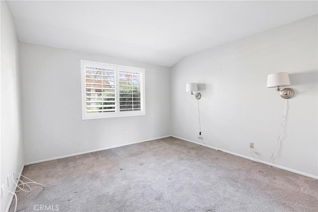 carpeted empty room with lofted ceiling