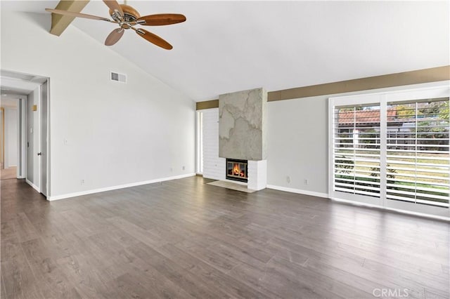 unfurnished living room featuring a large fireplace, dark wood-style flooring, visible vents, a ceiling fan, and beamed ceiling