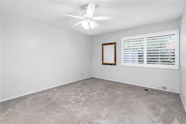 spare room with carpet floors, baseboards, and a ceiling fan