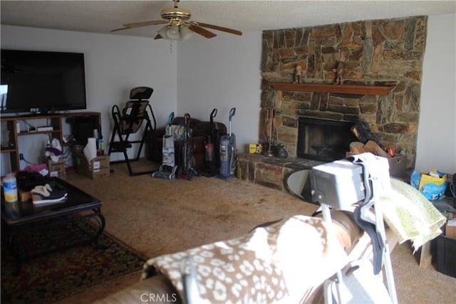 carpeted living room featuring ceiling fan and a fireplace