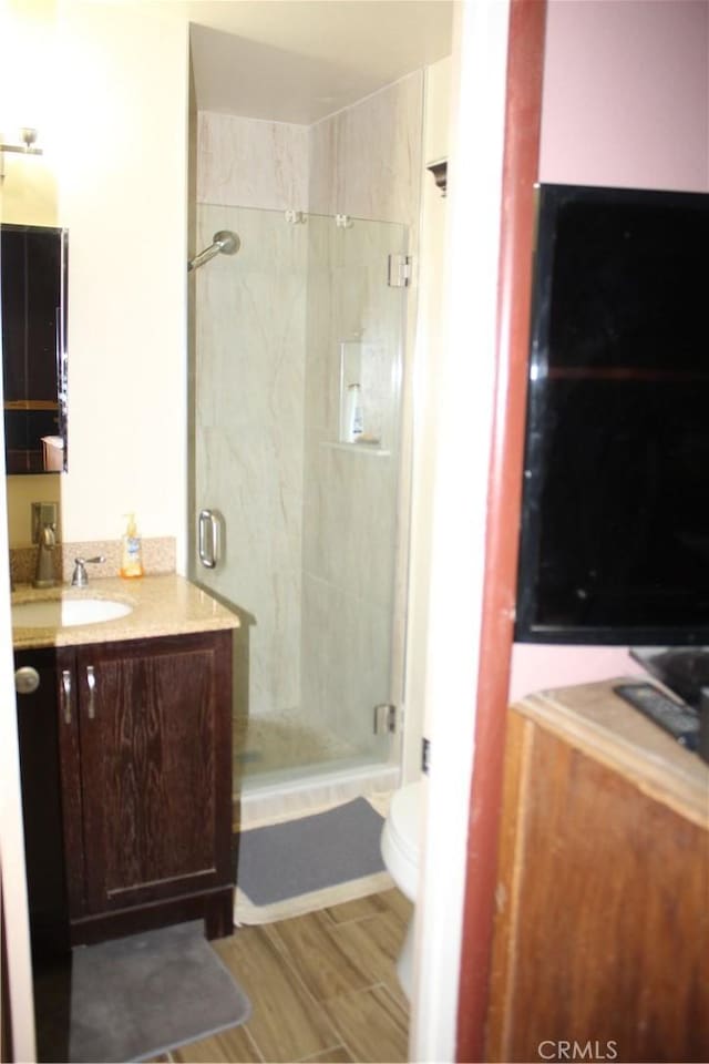 bathroom with tiled shower, vanity, and toilet