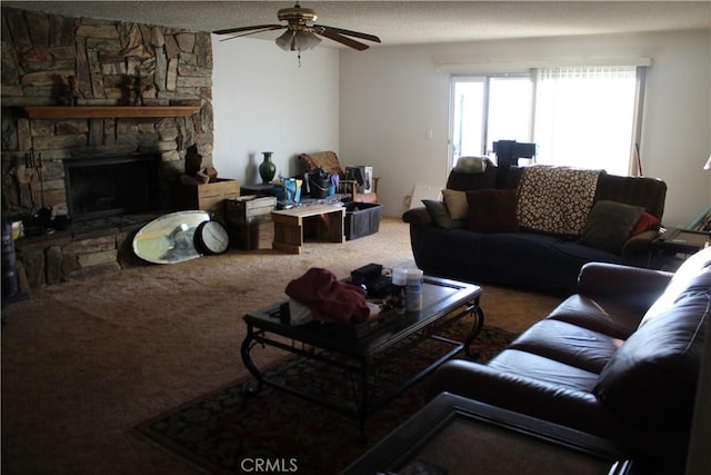 living room with a textured ceiling, ceiling fan, carpet flooring, and a fireplace