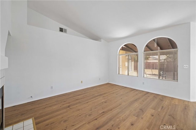 empty room with lofted ceiling and wood-type flooring