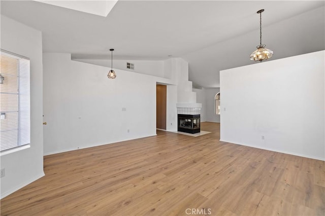 unfurnished living room featuring light wood-type flooring, vaulted ceiling, and a fireplace