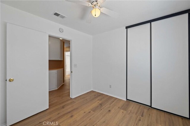 unfurnished bedroom with ceiling fan, a closet, and light hardwood / wood-style flooring