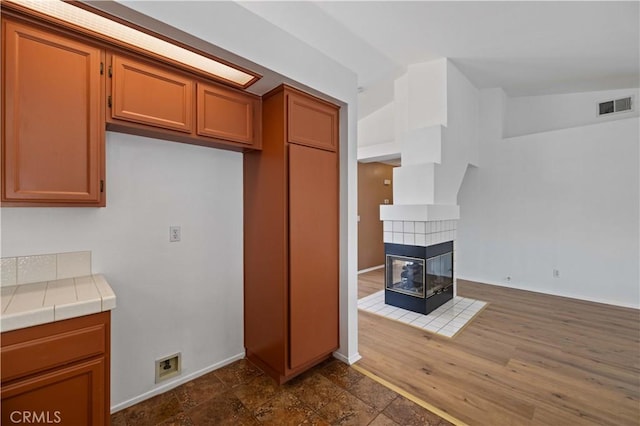 kitchen featuring tile counters and a fireplace