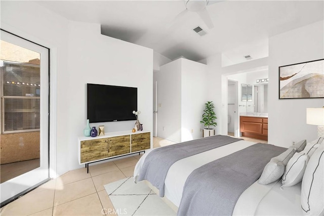 tiled bedroom featuring ceiling fan and connected bathroom