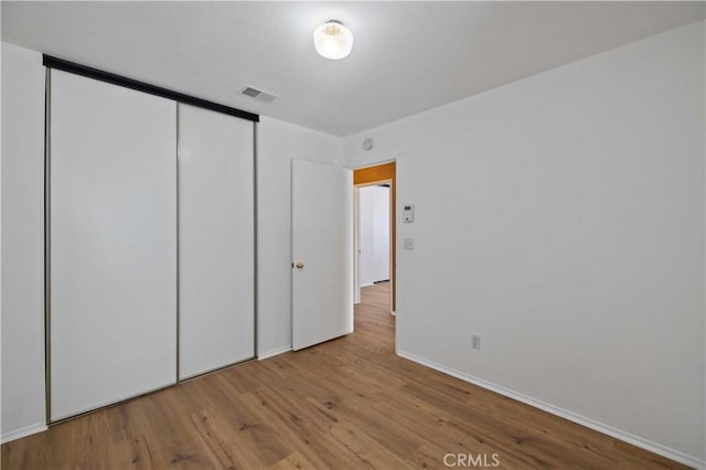 unfurnished bedroom with a closet and light hardwood / wood-style floors