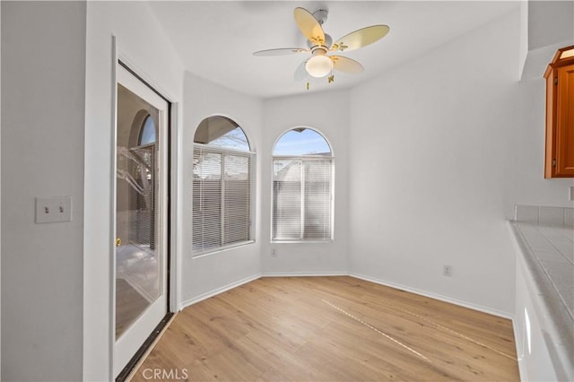 unfurnished dining area featuring ceiling fan and light hardwood / wood-style floors