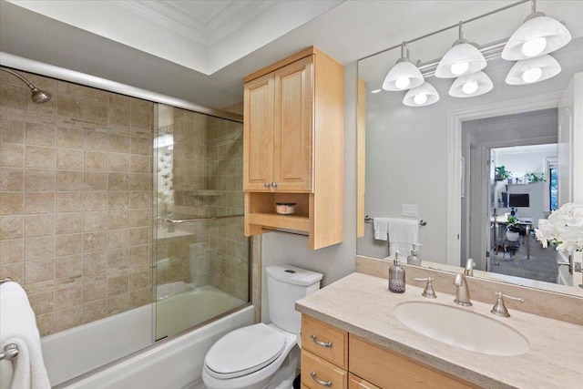 full bathroom featuring toilet, combined bath / shower with glass door, ornamental molding, and vanity