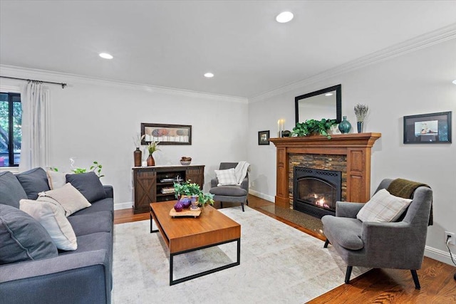 living room with light hardwood / wood-style flooring, ornamental molding, and a fireplace