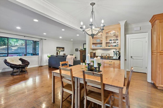 dining room with light hardwood / wood-style flooring, crown molding, and a chandelier