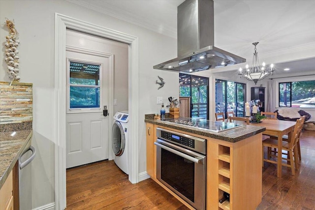 kitchen with oven, washer / clothes dryer, island exhaust hood, electric stovetop, and a chandelier