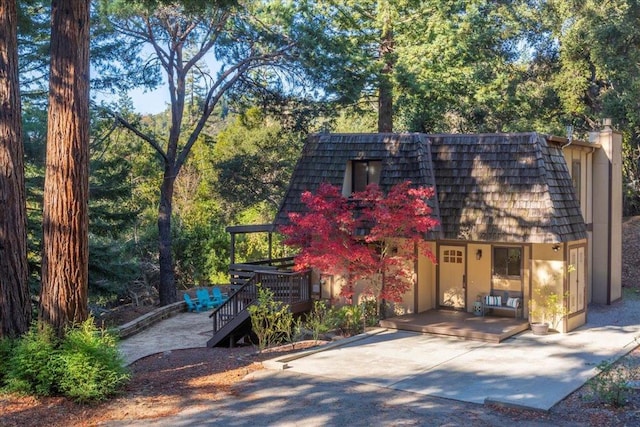 view of front of property featuring a deck and a patio