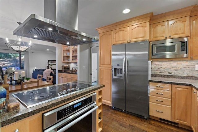 kitchen with exhaust hood, a notable chandelier, decorative backsplash, appliances with stainless steel finishes, and dark hardwood / wood-style flooring