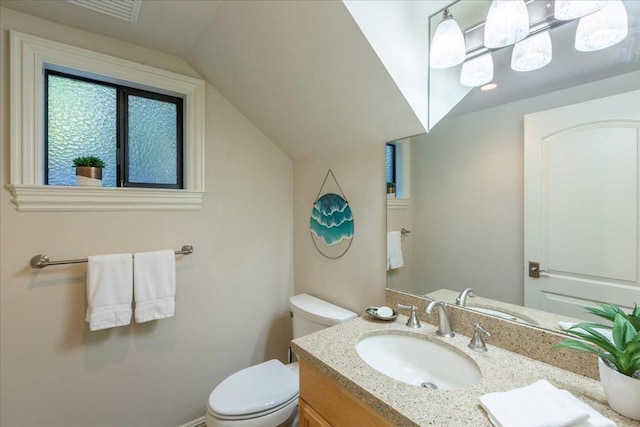 bathroom featuring toilet, lofted ceiling, and vanity