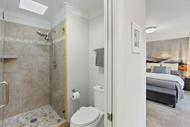 bathroom with a skylight, toilet, a shower with door, and crown molding