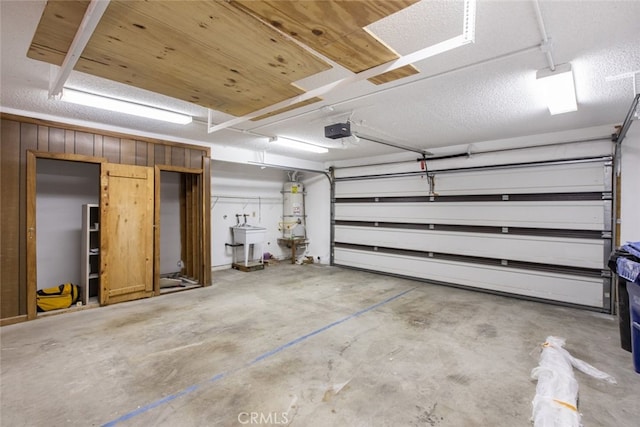 garage featuring a garage door opener and strapped water heater