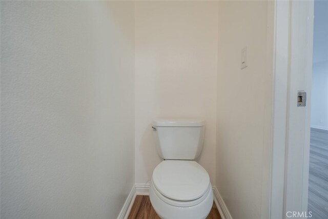 bathroom with toilet and wood-type flooring