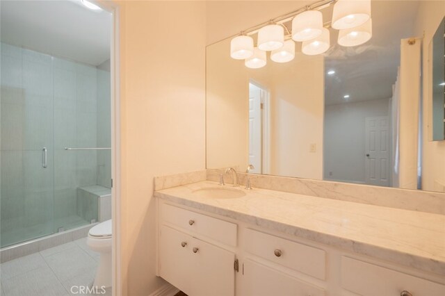 bathroom with toilet, tile patterned floors, a shower with shower door, and vanity