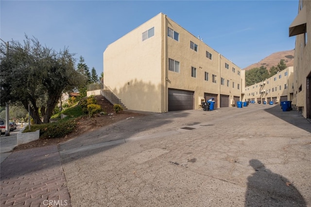 view of building exterior featuring a garage and a mountain view