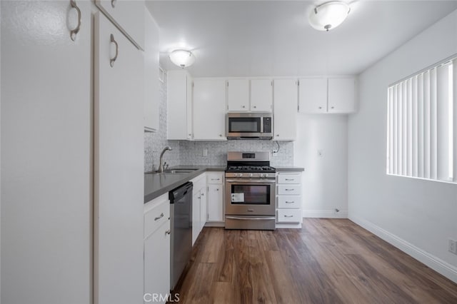 kitchen with decorative backsplash, sink, white cabinetry, dark wood-type flooring, and appliances with stainless steel finishes