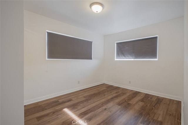 empty room with dark hardwood / wood-style flooring