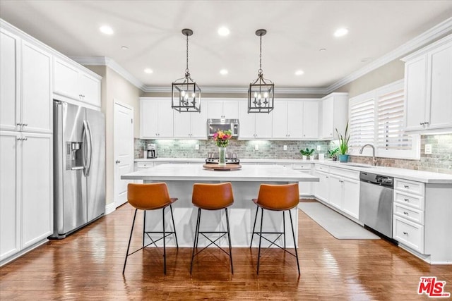 kitchen with white cabinets, sink, stainless steel appliances, and a kitchen island