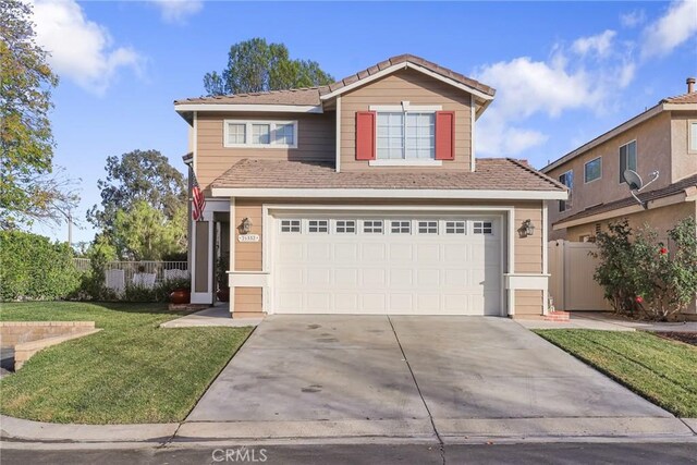 view of property featuring a front lawn and a garage