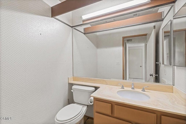 bathroom with toilet and vanity