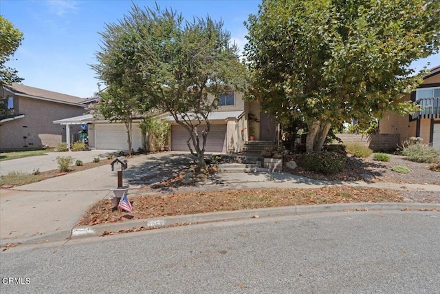 view of property hidden behind natural elements with a garage