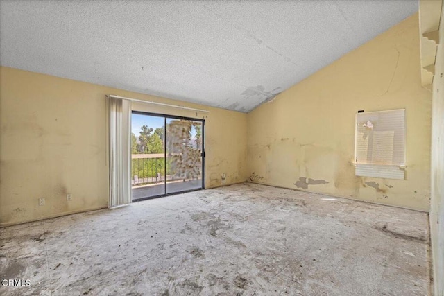 unfurnished room featuring a textured ceiling and lofted ceiling