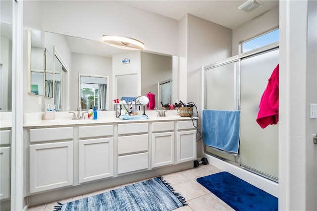 bathroom with walk in shower, vanity, and tile patterned flooring