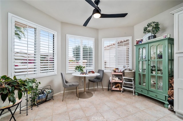 living area with light tile patterned floors and ceiling fan