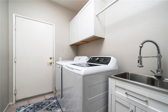 laundry room with light tile patterned flooring, cabinets, sink, and washing machine and dryer