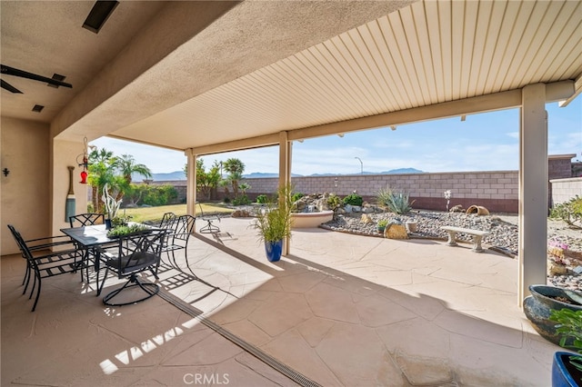 view of patio / terrace with ceiling fan and a mountain view