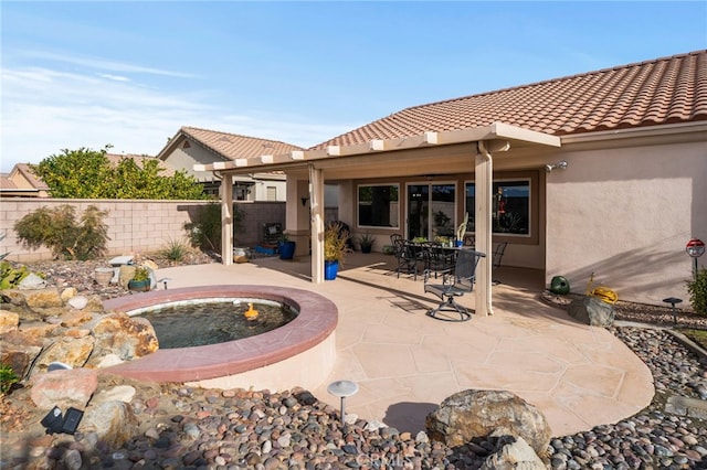 rear view of house with a jacuzzi and a patio