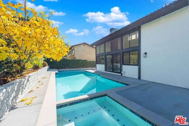 view of swimming pool featuring an in ground hot tub