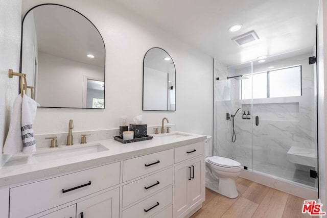 bathroom featuring walk in shower, vanity, toilet, and hardwood / wood-style flooring