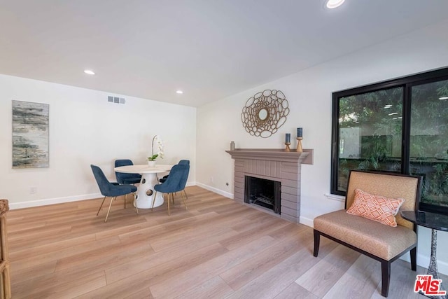 living area with light hardwood / wood-style floors and a fireplace