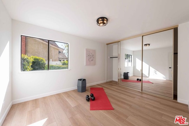 workout room with light hardwood / wood-style floors