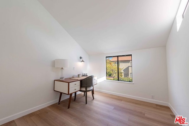 office area with light hardwood / wood-style floors and lofted ceiling