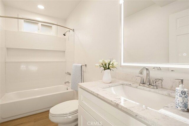 full bathroom featuring toilet, shower / washtub combination, wood-type flooring, and vanity