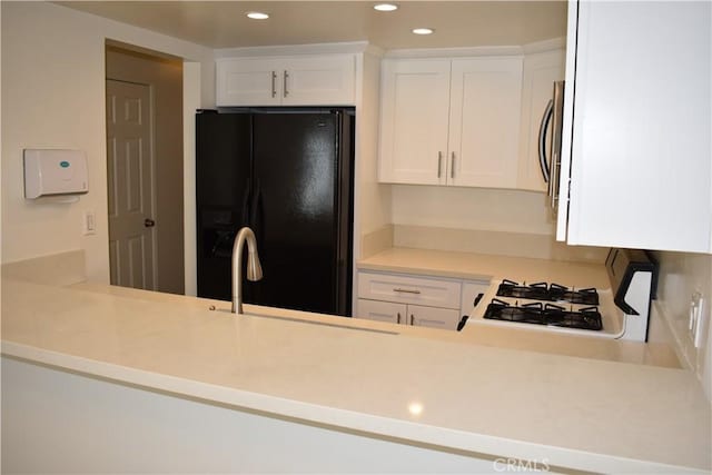 1718 Puente Ave Unit 40, Baldwin Park, CA 91706 - kitchen with black fridge, recessed lighting, white cabinetry, light countertops, and stainless steel microwave