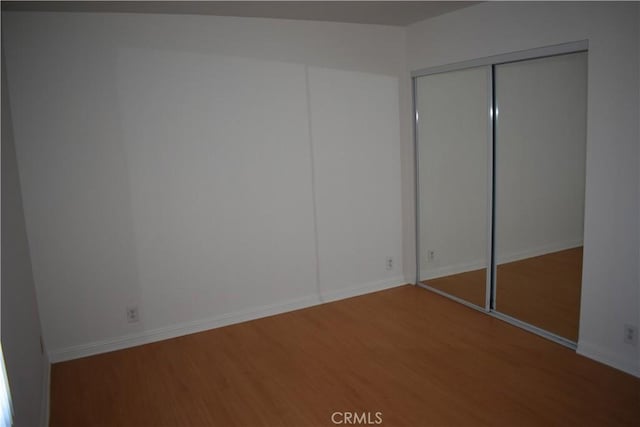 1718 Puente Ave Unit 40, Baldwin Park, CA 91706 - unfurnished bedroom with wood finished floors, a closet, and baseboards