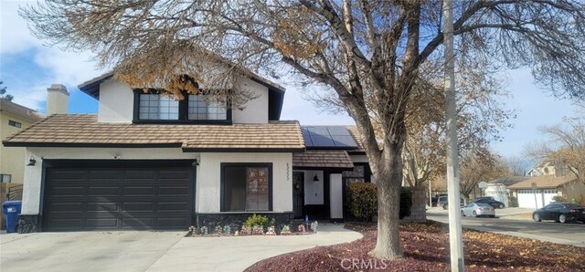 view of front facade with solar panels and a garage