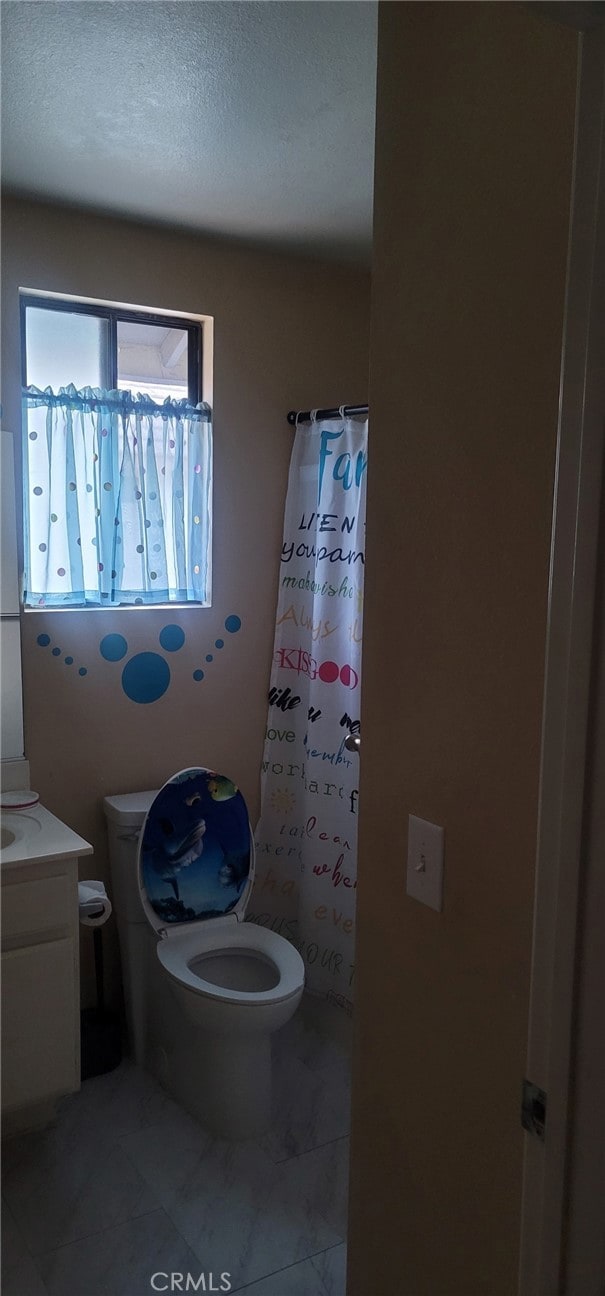 bathroom with toilet, a textured ceiling, and vanity